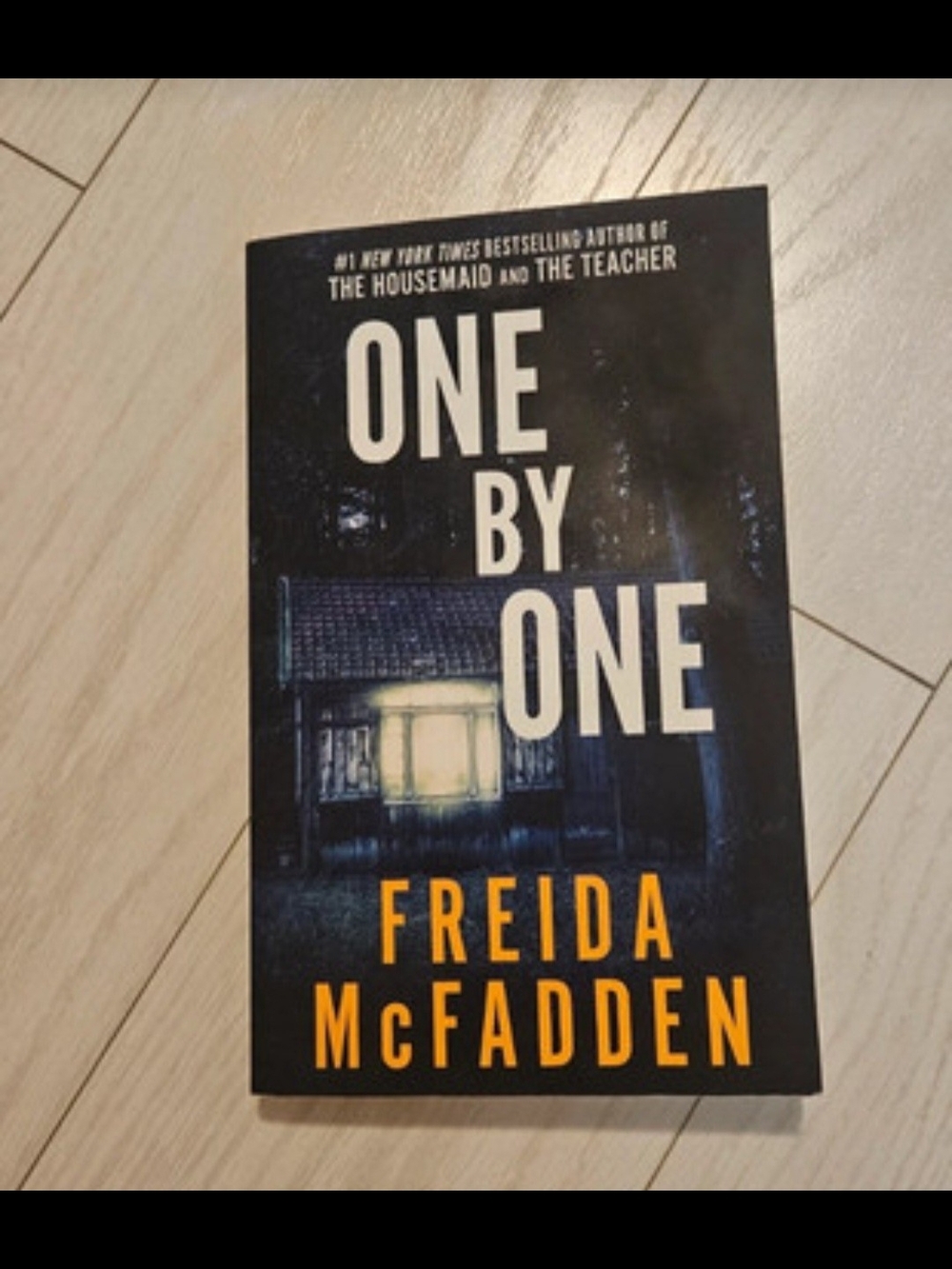 One By One by Freida McFadden - Dark Blue & Black Paperback Thriller